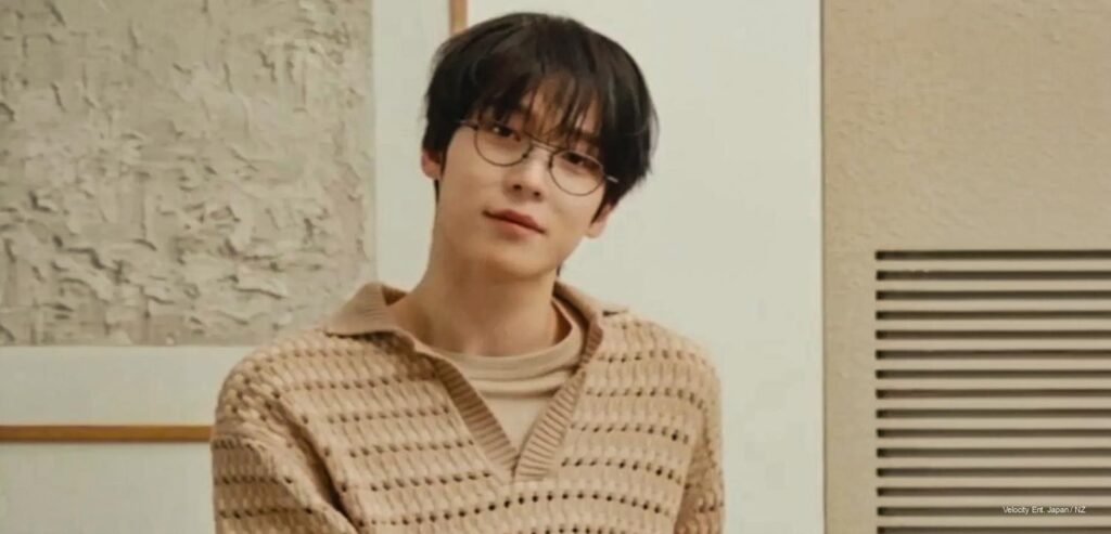 Yunho of ATEEZ wearing Maison Kitsuné S/S 2026, airport look, brown and cream tones, fashion editorial