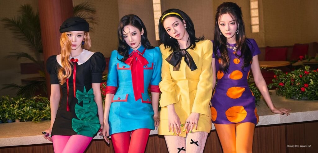 aespa member in cobalt blue mod coat with red trim, holding a yellow lemon — LEMONADE MV 2026