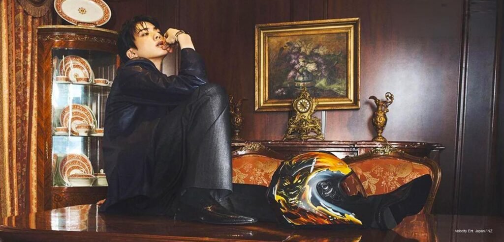 BTS's Jin seated in an ornate wood-paneled room wearing black Gucci tailoring for ELLE Korea's August 2026 cover story