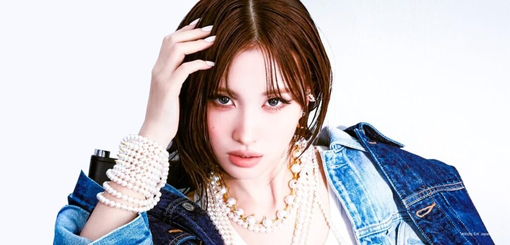 Momo x TASAKI — ELLE Japan September 2026 TWICE's Momo in a close-up beauty shot for ELLE Japan x TASAKI, wearing layered TASAKI pearl necklaces and a stacked pearl bracelet with a denim jacket, one hand raised through wet-look hair