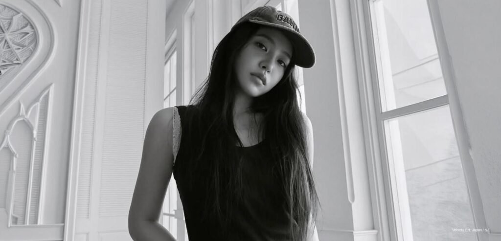 Yeri for DAZED Korea August 2026 Yeri of Red Velvet posing in a bright fashion portrait with long dark hair, a checkered top, and a turquoise cardigan draped over her shoulders.