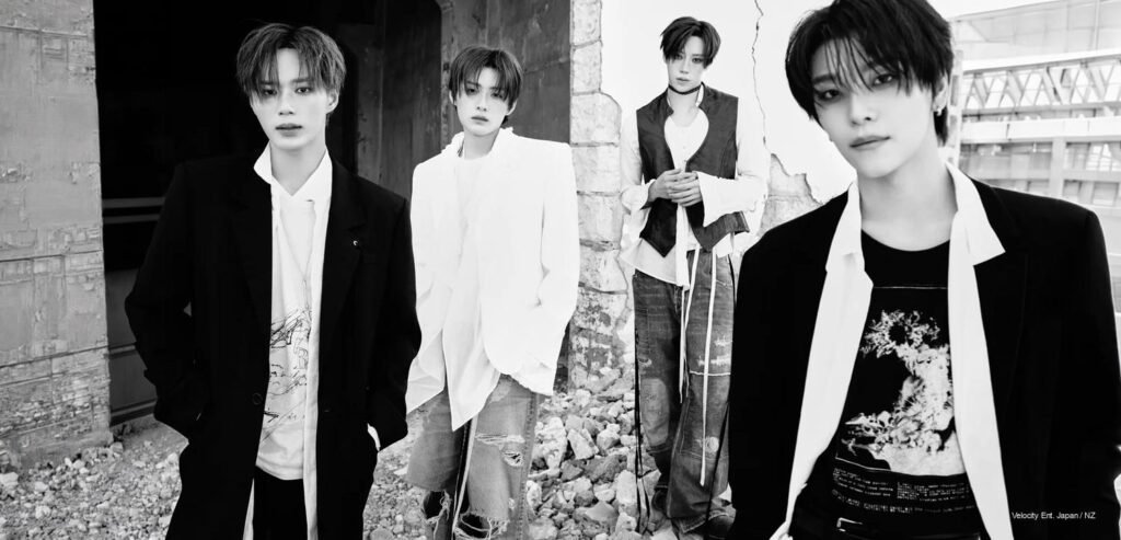 ALPHA DRIVE ONE UNBREAKABLE group concept photo, four members in monochrome tailoring against a cracked concrete ruin