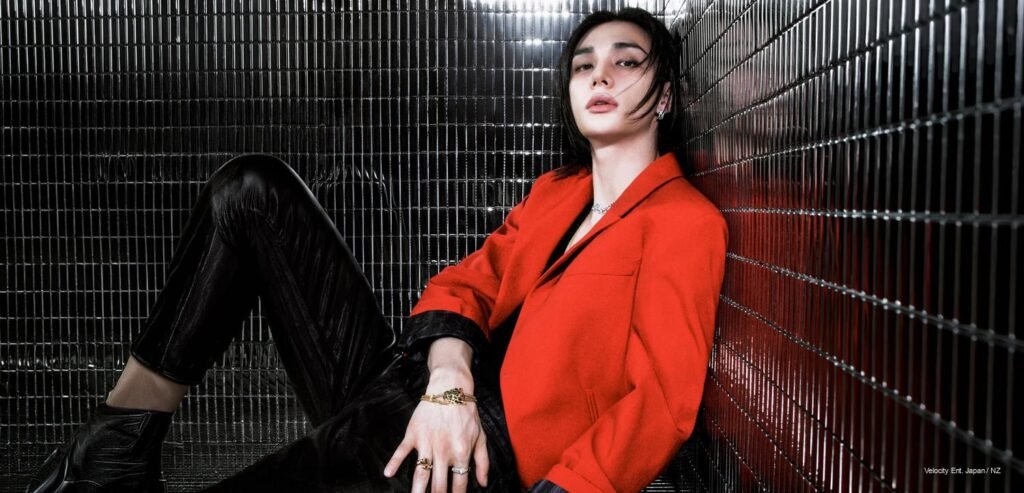 Stray Kids Hyunjin reclining in a vibrant red blazer and black leather pants against a reflective chrome-tiled grid background for W Korea x Cartier September 2026 issue.