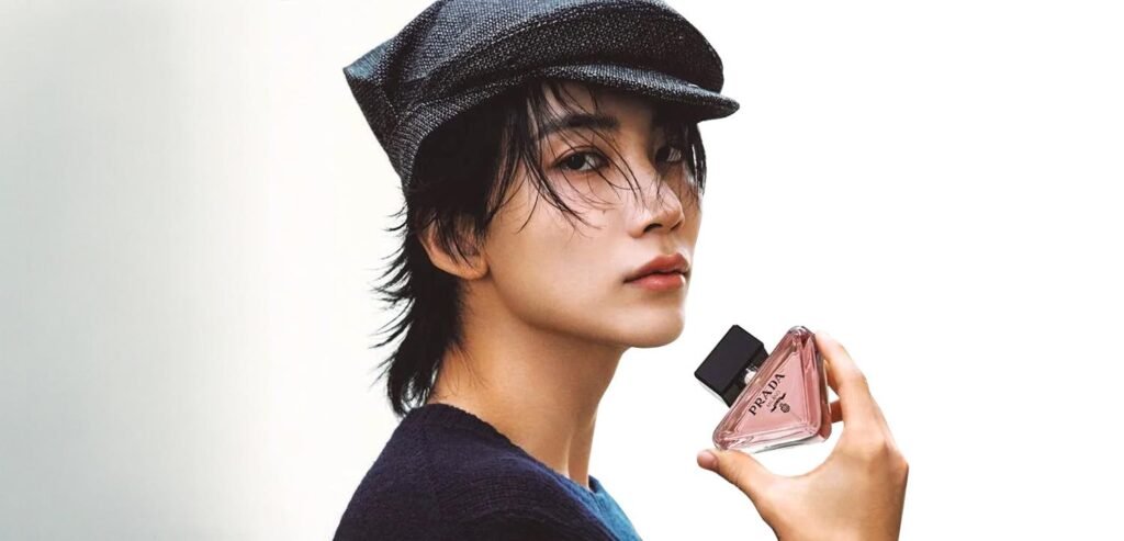 SEVENTEEN's Jeonghan poses in a tweed cap and navy knit holding a Prada Beauty fragrance bottle for ELLE Japan's October 2026 issue.