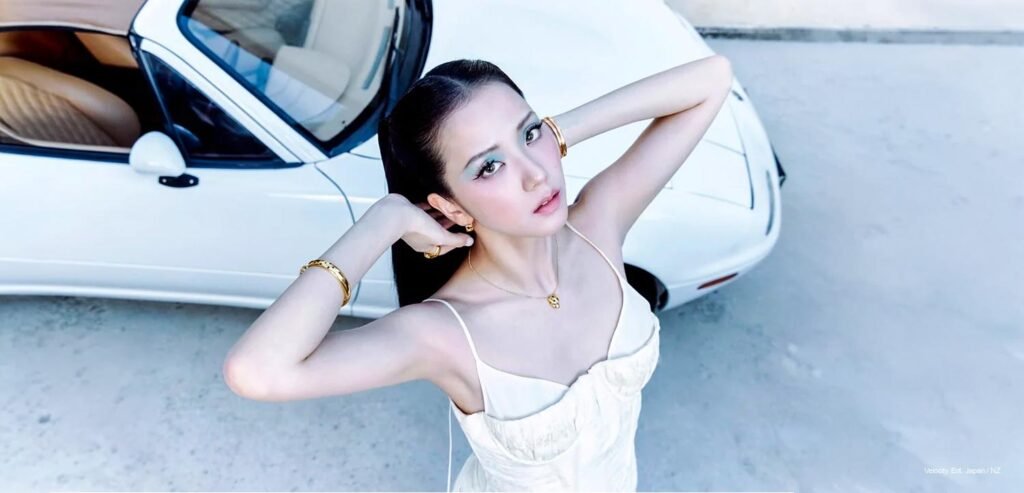 Jisoo — W Korea x Cartier Jisoo poses with hands framing her face beside a white sports car, wearing gold Cartier cuffs and a white slip dress, W Korea x Cartier September 2026