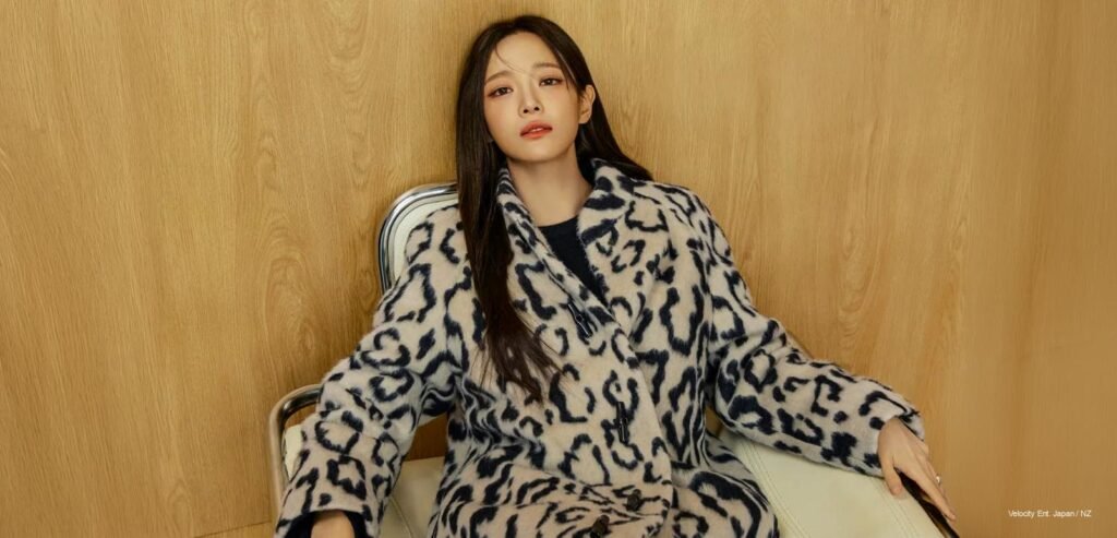 Kim Sejeong posing in an olive Longchamp tailored jacket and beige culottes against a vibrant green backdrop for Marie Claire Korea 2026.