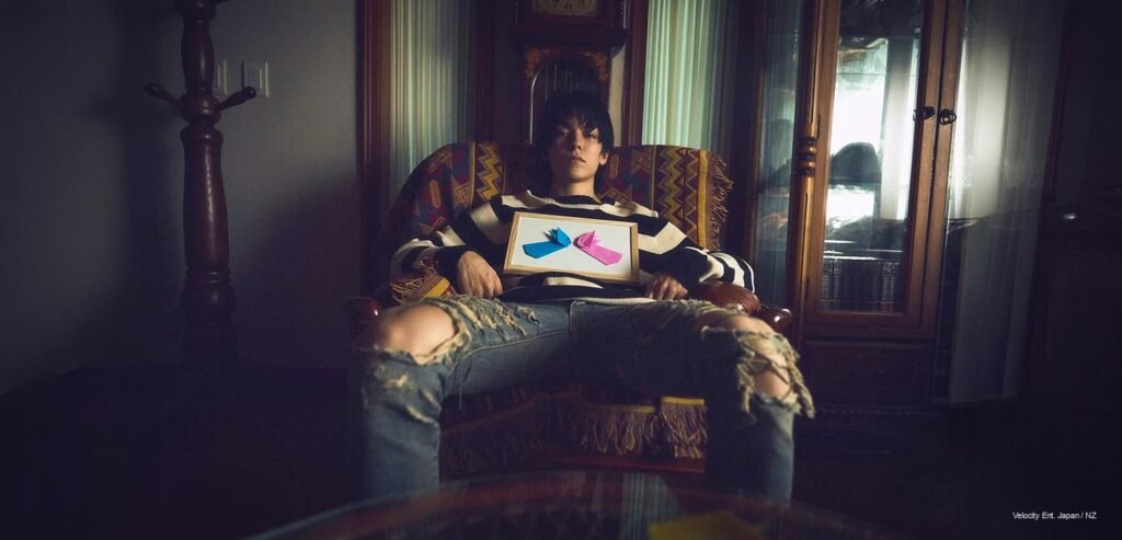 Vernon — GQ Korea September 2026 SEVENTEEN's Vernon seated in a vintage armchair wearing ripped denim and a striped knit sweater, holding a framed origami art piece, for GQ Korea September 2026.