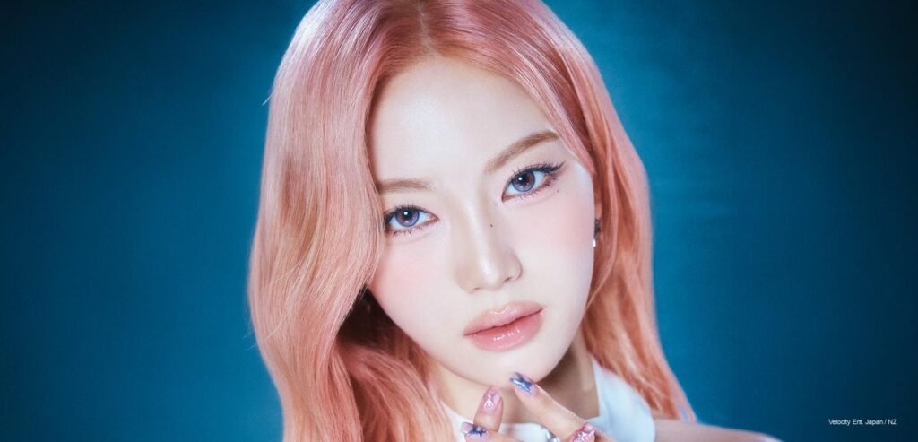 STAYC member posing in a futuristic white outfit seated inside a translucent chrome bubble chair for the 2026 Fan Concert Tour STAY CLOSER individual poster.