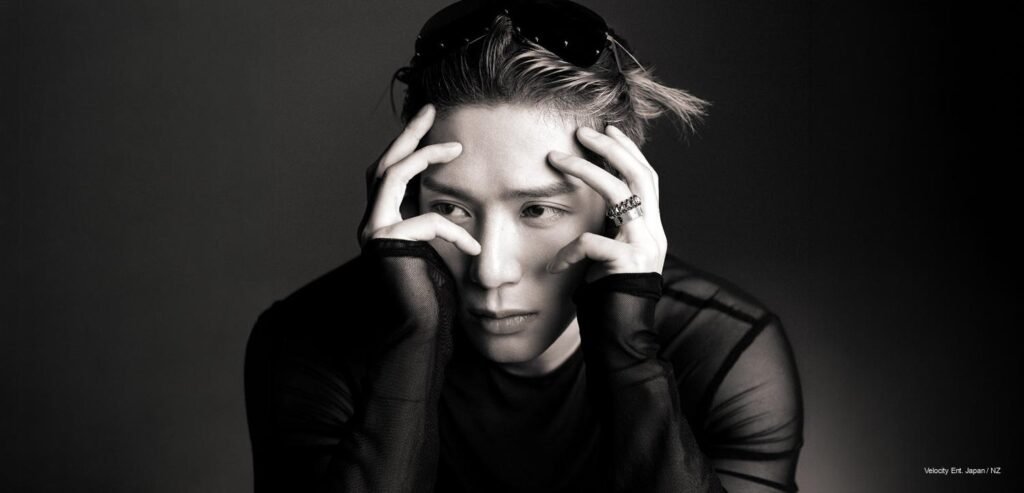Jackson Wang leaning head on hands wearing sheer Rick Owens top and Cartier ring for GQ cover photoshoot.